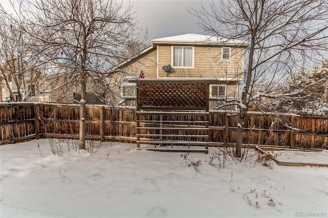 view of snow covered rear of property