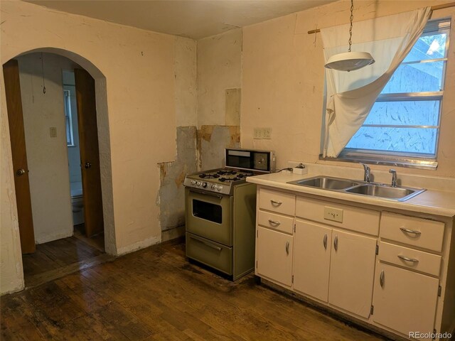 4209 Perry St, Denver, CO 80212 - kitchen with gas range gas stove, light countertops, dark wood-style flooring, white cabinets, and arched walkways