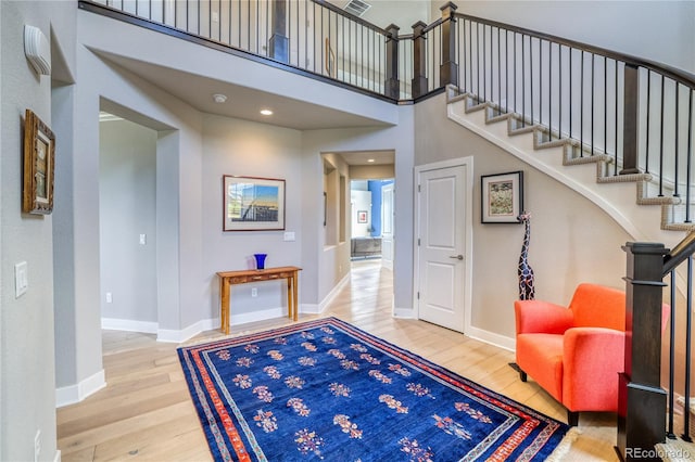 entrance foyer with hardwood / wood-style floors and a high ceiling