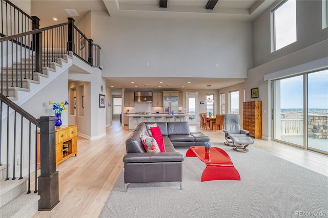 living room featuring a high ceiling and light hardwood / wood-style flooring