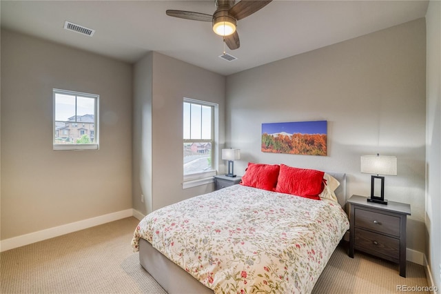 bedroom featuring multiple windows, light carpet, and ceiling fan