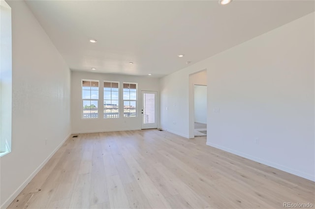 unfurnished room with light wood finished floors, recessed lighting, and baseboards