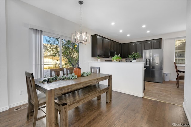 dining space with dark hardwood / wood-style floors and a chandelier