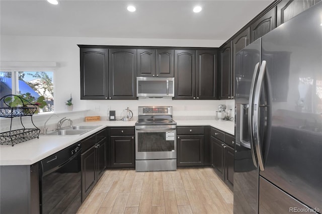 kitchen with stainless steel appliances, sink, and light hardwood / wood-style floors