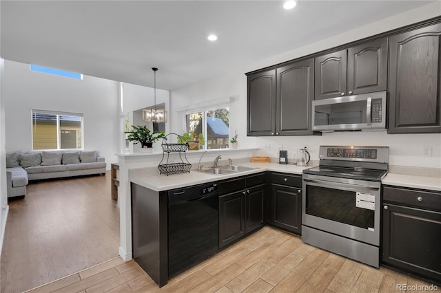 kitchen with pendant lighting, appliances with stainless steel finishes, an inviting chandelier, and sink