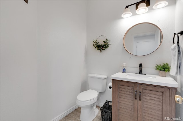 bathroom with vanity, toilet, and wood-type flooring