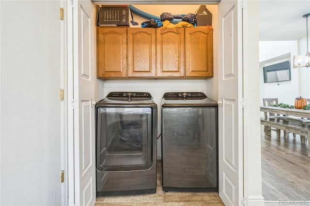 washroom featuring cabinets and separate washer and dryer