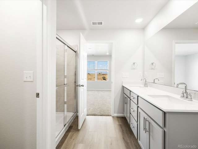 22360 E 8th Ave, Aurora, CO 80018 - bathroom featuring visible vents, a sink, a stall shower, and wood finished floors