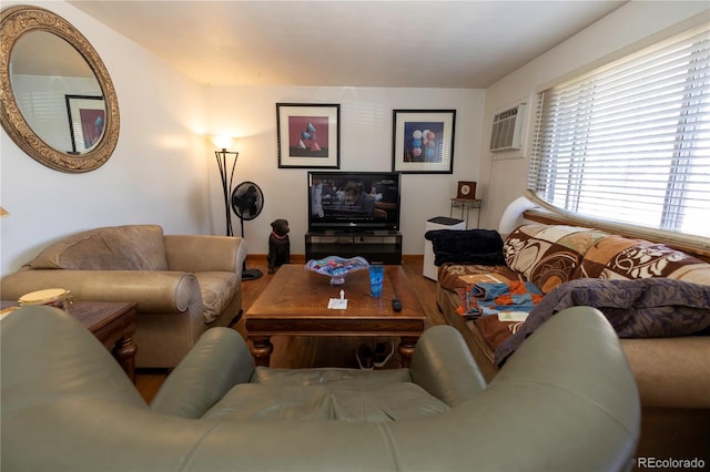 living room featuring hardwood / wood-style floors and a wall unit AC