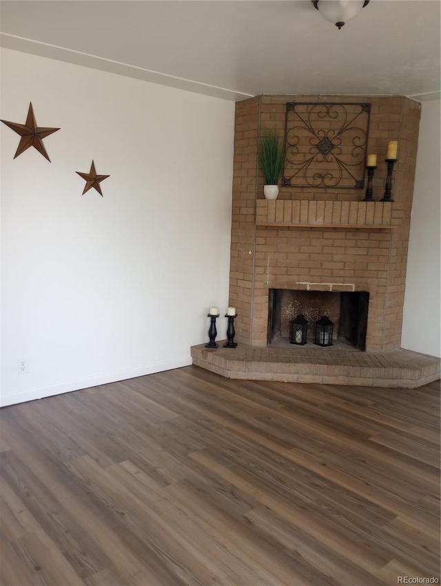 5640 E 67th Pl, Commerce City, CO 80022 - unfurnished living room featuring baseboards, a fireplace, and wood finished floors