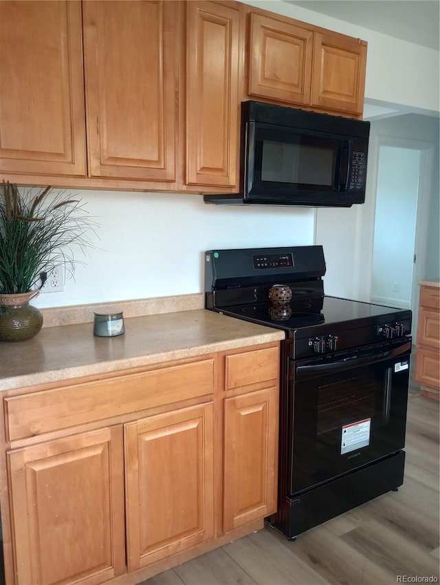 5640 E 67th Pl, Commerce City, CO 80022 - kitchen with light countertops, light brown cabinetry, black appliances, and light wood-type flooring