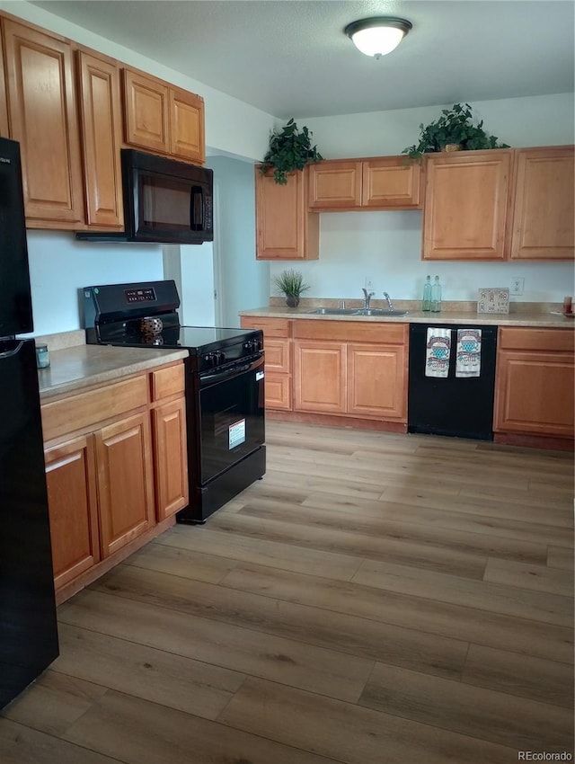 5640 E 67th Pl, Commerce City, CO 80022 - kitchen with a sink, light countertops, black appliances, and light wood-style flooring