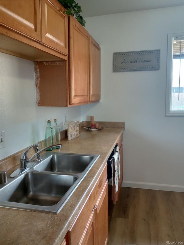 5640 E 67th Pl, Commerce City, CO 80022 - kitchen featuring brown cabinetry, wood finished floors, baseboards, a sink, and dishwasher