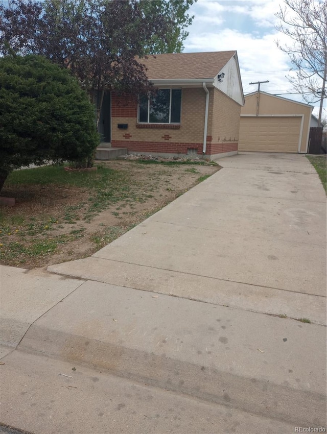 5640 E 67th Pl, Commerce City, CO 80022 - view of front of house with a detached garage, an outdoor structure, roof with shingles, and brick siding