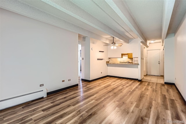 1265 Elizabeth St Unit 207, Denver, CO 80206 - unfurnished living room with baseboard heating, ceiling fan, and wood finished floors