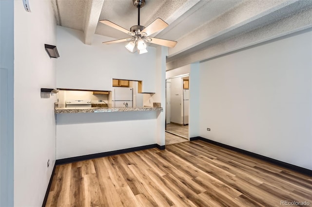 1265 Elizabeth St Unit 207, Denver, CO 80206 - living area with wood finished floors, ceiling fan, a textured ceiling, and beam ceiling