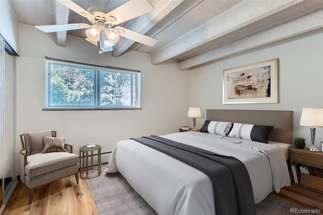 1265 Elizabeth St Unit 207, Denver, CO 80206 - bedroom featuring wood finished floors, beamed ceiling, and ceiling fan