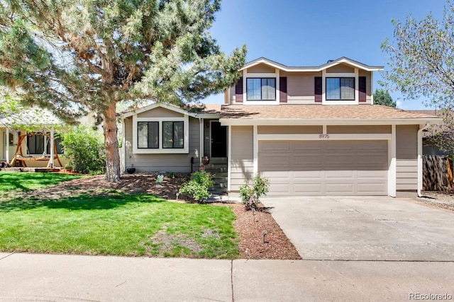 tri-level home with a front lawn, driveway, a shingled roof, and a garage