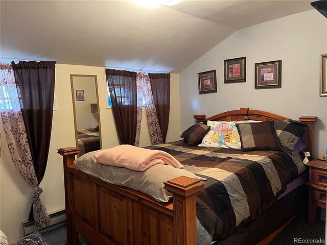 bedroom featuring a baseboard heating unit and vaulted ceiling