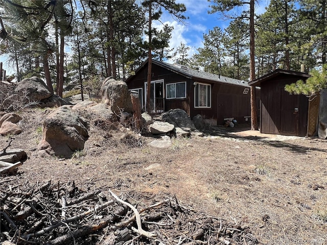 view of side of home with a storage shed and an outbuilding