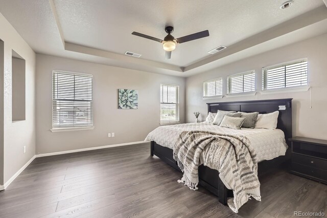 785 Iris St, Brighton, CO 80601 - bedroom featuring a raised ceiling, dark wood-style floors, and a ceiling fan