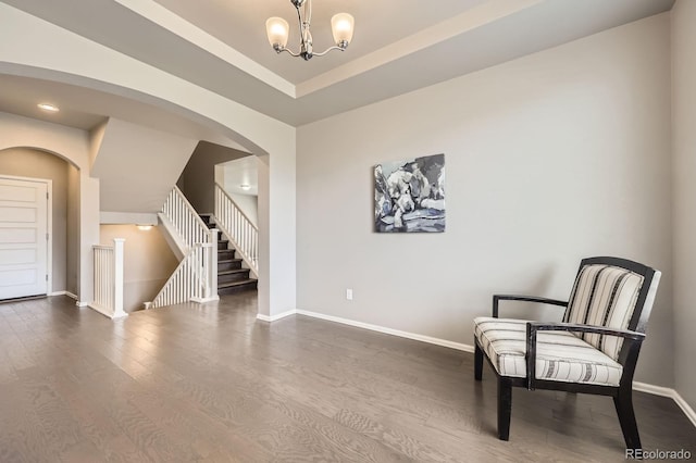 785 Iris St, Brighton, CO 80601 - unfurnished room featuring dark wood-style floors, stairway, arched walkways, and a chandelier