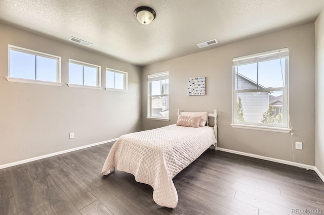 785 Iris St, Brighton, CO 80601 - bedroom featuring dark wood-style floors and a textured ceiling