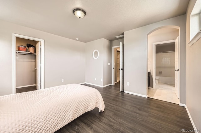 785 Iris St, Brighton, CO 80601 - bedroom featuring arched walkways, dark wood finished floors, connected bathroom, and a closet