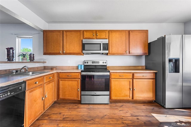 4528 Andes St, Denver, CO 80249 - kitchen featuring stainless steel appliances, a sink, brown cabinetry, and dark wood finished floors