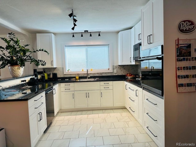 kitchen with decorative backsplash, a wealth of natural light, a sink, and dishwashing machine