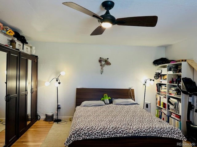 bedroom with light wood-type flooring and ceiling fan