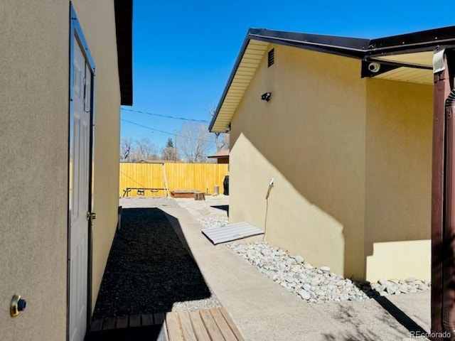 view of home's exterior featuring fence, a patio, and stucco siding