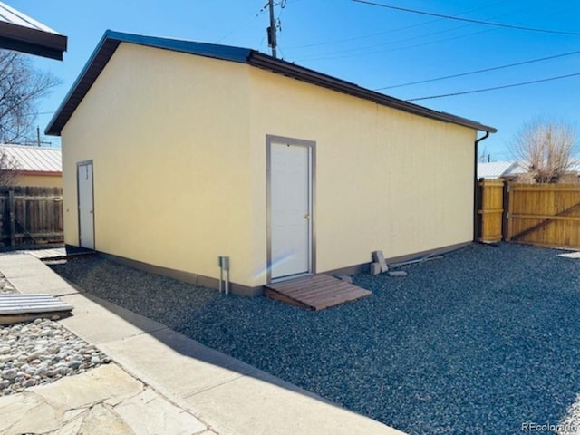 rear view of house featuring fence and stucco siding