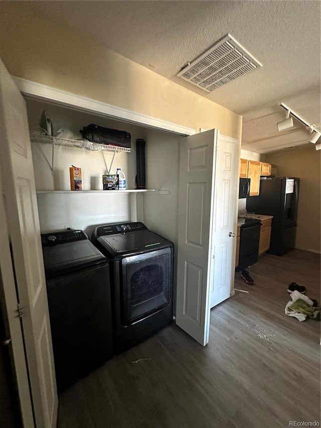 5255 Memphis St Unit 121, Denver, CO 80239 - laundry room featuring washer and clothes dryer, dark wood-style flooring, and a textured ceiling