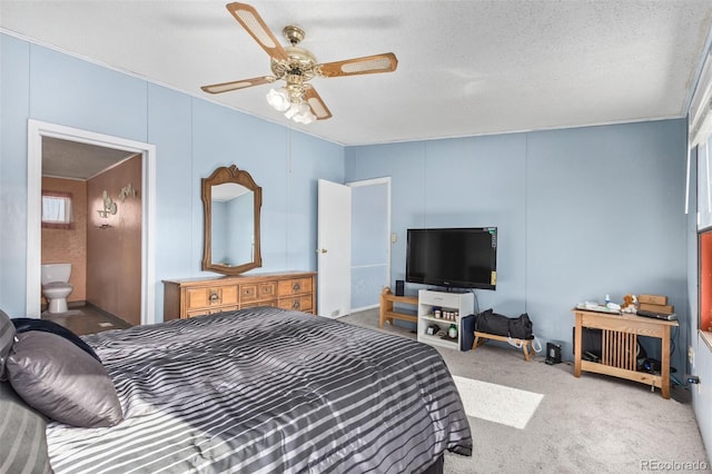 carpeted bedroom featuring a textured ceiling, connected bathroom, and ceiling fan