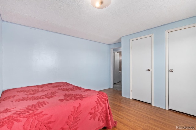 bedroom featuring light hardwood / wood-style flooring and a textured ceiling