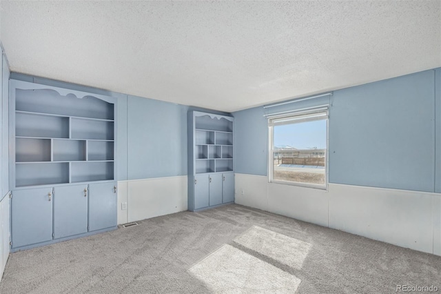 unfurnished bedroom featuring light carpet and a textured ceiling