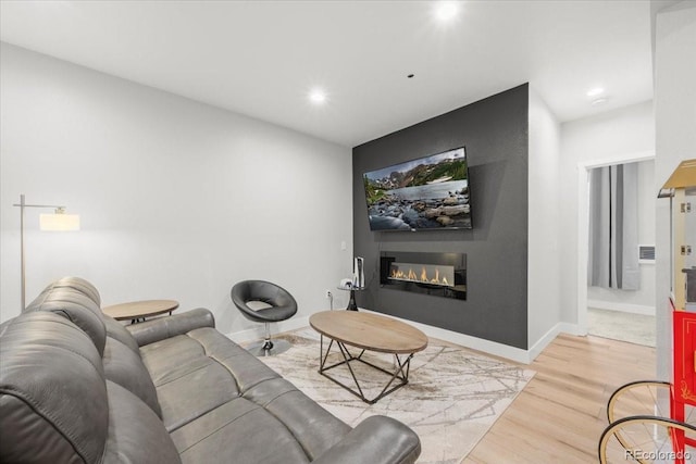 5100 Eaglewood Ln, Johnstown, CO 80534 - living area featuring light wood finished floors, a glass covered fireplace, and recessed lighting