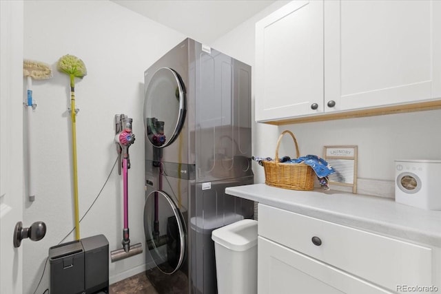 5100 Eaglewood Ln, Johnstown, CO 80534 - laundry room featuring stacked washing machine and dryer and cabinet space
