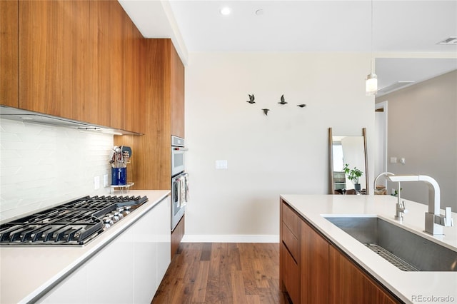 4200 W 17th Ave Unit 611, Denver, CO 80204 - kitchen featuring modern cabinets, stainless steel appliances, a sink, brown cabinetry, and tasteful backsplash