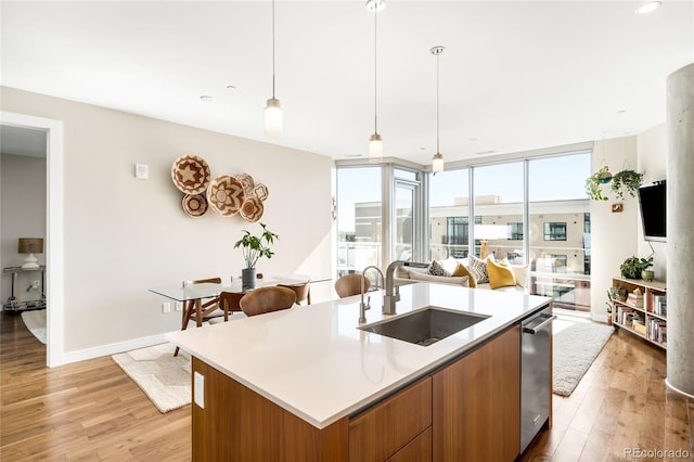 4200 W 17th Ave Unit 611, Denver, CO 80204 - kitchen with a sink, brown cabinets, open floor plan, and light wood-style floors