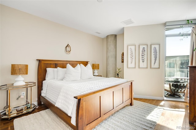 4200 W 17th Ave Unit 611, Denver, CO 80204 - bedroom featuring wood finished floors, multiple windows, and baseboards