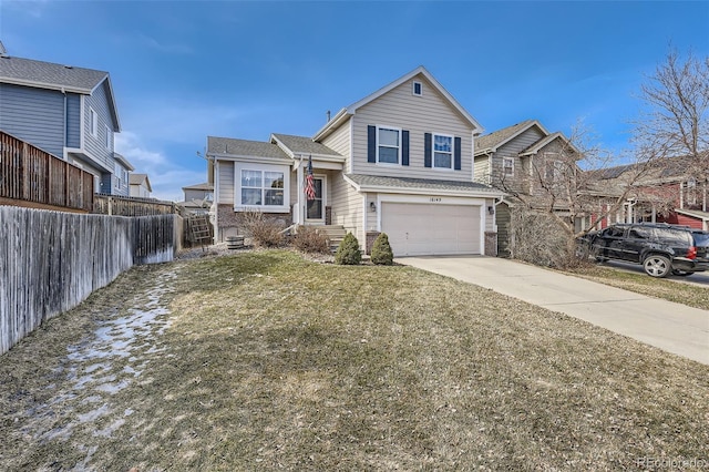 tri-level home with an attached garage, concrete driveway, a front lawn, and fence