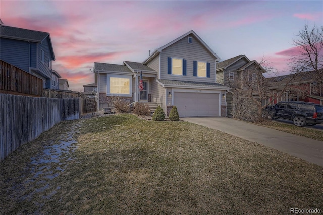 view of front of home featuring concrete driveway, an attached garage, fence, and a front lawn