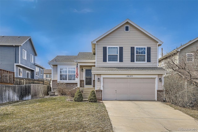 tri-level home featuring fence, concrete driveway, a front yard, a garage, and brick siding