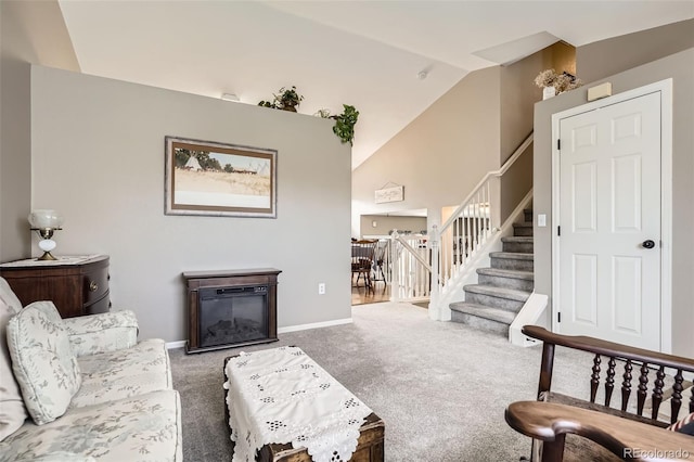 living room with baseboards, stairway, vaulted ceiling, carpet floors, and a glass covered fireplace