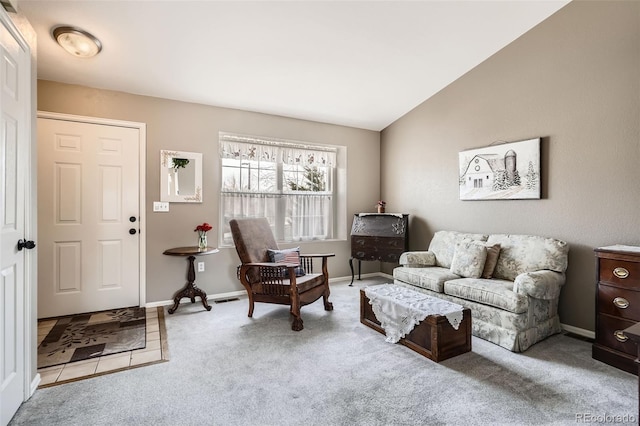 carpeted living area with visible vents, baseboards, and lofted ceiling