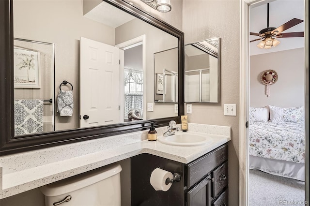 ensuite bathroom featuring connected bathroom, toilet, ceiling fan, and vanity