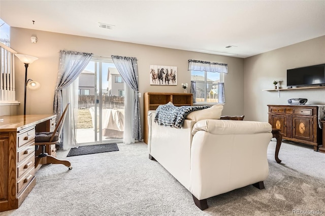 living room with a wealth of natural light, visible vents, and carpet floors