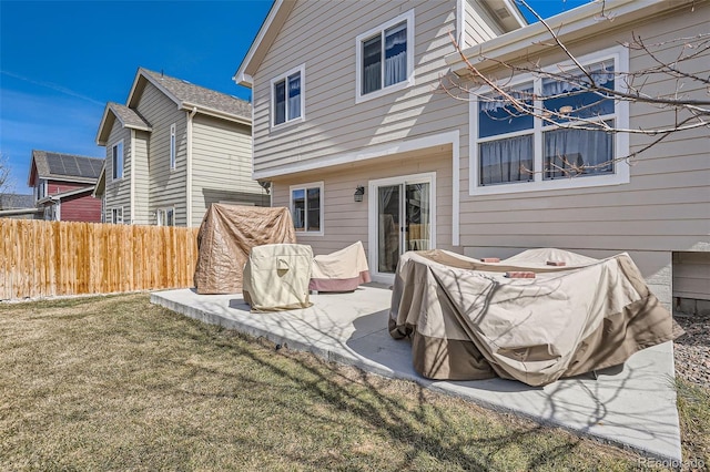 rear view of property with a lawn, a patio, and fence